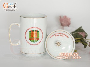 Cốc sứ dáng cao quai nắm men trắng kẻ chỉ vàng kim in logo CA TP HCM, 500ml