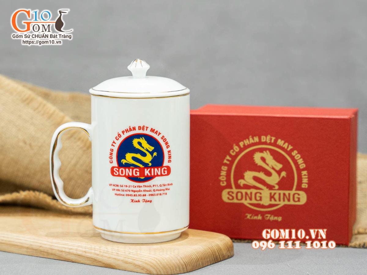 Cốc sứ dáng cao quai nắm men trắng kẻ chỉ vàng kim in logo CA TP HCM, 500ml Cốc sứ dáng cao quai nắm men trắng kẻ chỉ vàng kim in logo CA TP HCM, 500ml