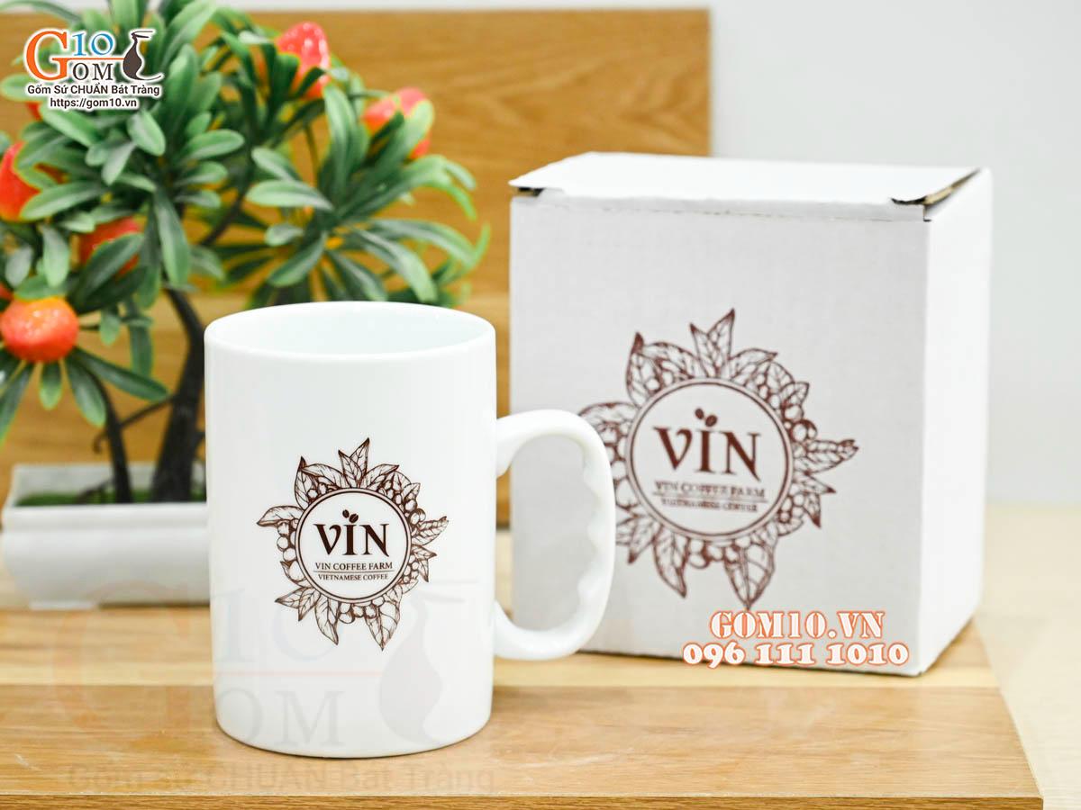 Cốc sứ dáng cao quai nắm men trắng kẻ chỉ vàng kim in logo CA TP HCM, 500ml